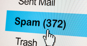 A close-up of a computer screen showing a user clicking on the "Spam (372)" button with a cursor.