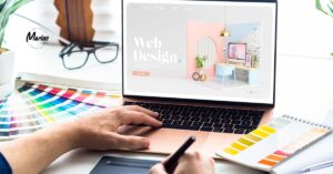 Designer working on a web design mockup with color swatches and a laptop.