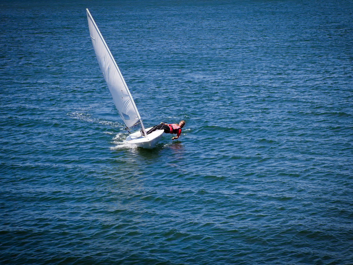 photo of someone sailing a small sailboat